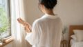白いシャツを着た朝・鏡で肌の調子を見るはるか