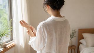白いシャツを着た朝・鏡で肌の調子を見るはるか