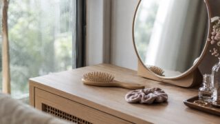 窓辺の木の鏡台に置かれた木製ブラシとヘアゴム