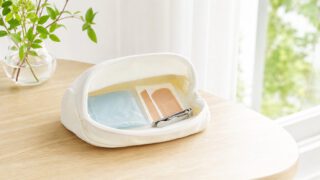 夏の木のテーブルに置かれた保冷剤と絆創膏と爪切りのポーチ